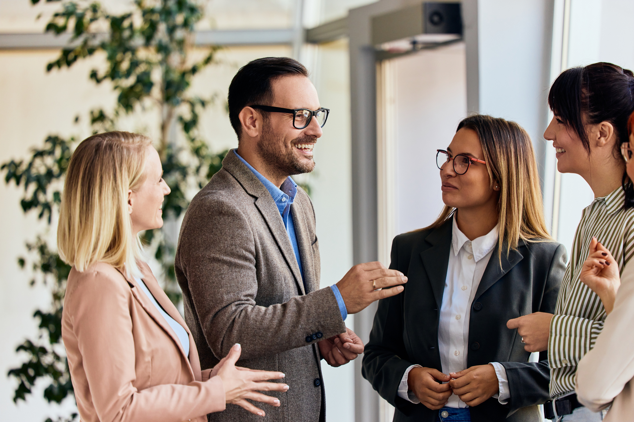 Four professionals standing together, having a conversation